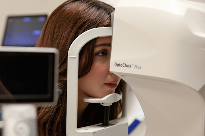 Woman having retinal scan during complete eye exam